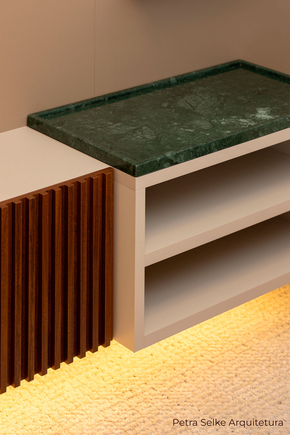 Móvel de sala de TV com frente de gaveta ripada em madeirado escuro, prateleira em MDF claro e bandeja de mármore Verde Alpi