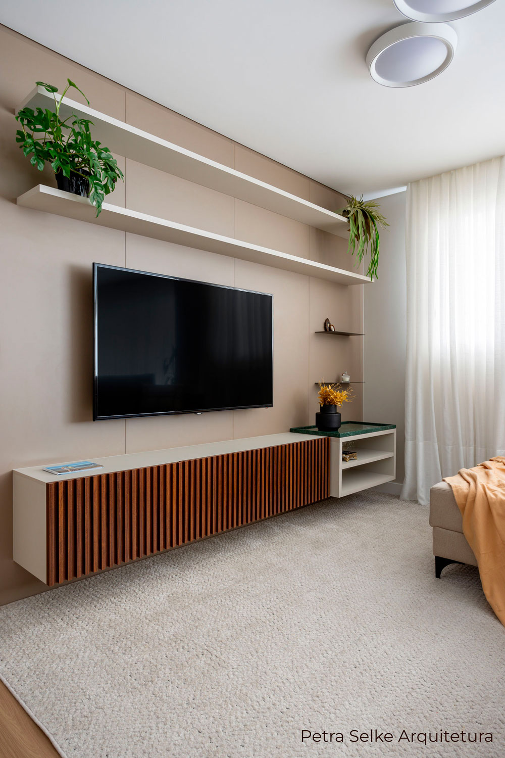 Sala de TV aconchegante em MDF com cor bege e móvel com frentes ripadas em madeirado